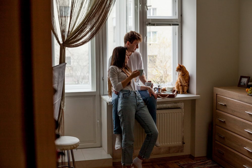 couple standing by the window and central heating